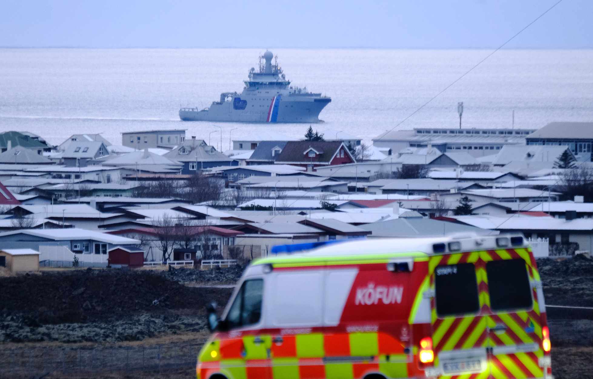 An ambulance lingers just outside of Grindavík