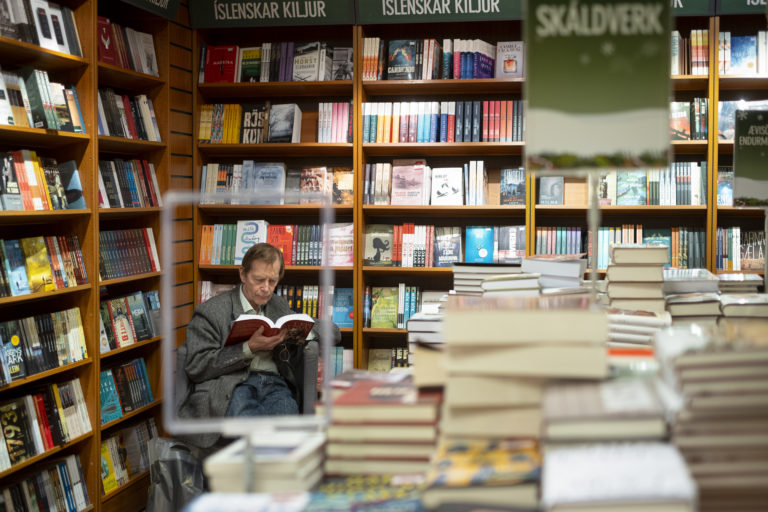 A man reading in a book shop corner.